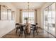 Bright dining area with wood floors, a modern chandelier, and sliding glass doors to the backyard at 15655 Woodford Dr, Westfield, IN 46074
