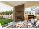 Covered patio with an outdoor fireplace, grill, and seating area perfect for entertaining at 15655 Woodford Dr, Westfield, IN 46074