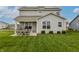 Backyard featuring a covered patio, green lawn, and solar panels on the roof at 16080 Cabin Hill Dr, Noblesville, IN 46060
