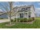 Charming two-story home featuring a welcoming front porch, three-car garage and a manicured lawn at 16080 Cabin Hill Dr, Noblesville, IN 46060