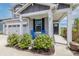 Inviting front porch features two blue rocking chairs, lush landscaping, and a modern entry door at 16080 Cabin Hill Dr, Noblesville, IN 46060