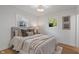 Cozy bedroom with neutral tones, plush bedding, hardwood floors and natural light from windows with green views at 165 N 9Th St, Zionsville, IN 46077