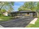 Beautifully landscaped home with a dark painted exterior, well-kept lawn, and mature trees at 165 N 9Th St, Zionsville, IN 46077