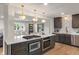 Kitchen features a spacious island with a gas cooktop, stainless steel appliances, and an open view to the living room at 165 N 9Th St, Zionsville, IN 46077