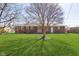 Brick home surrounded by green grass and a large tree in the backyard at 166 N Post Rd, Indianapolis, IN 46219