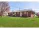 Large backyard with red brick house and green grass at 166 N Post Rd, Indianapolis, IN 46219