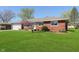 Well-maintained brick home featuring a lush green lawn and landscaped garden at 166 N Post Rd, Indianapolis, IN 46219
