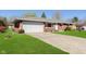 Brick home with a large driveway, lawn, and an attached two car garage at 166 N Post Rd, Indianapolis, IN 46219