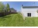 Back yard with sloping lawn and partially exposed basement, offers outdoor space and privacy at 1809 Ernest Ct, Indianapolis, IN 46234