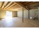 Unfinished basement with exposed ceiling, white shelving, and natural light from sliding glass door at 1809 Ernest Ct, Indianapolis, IN 46234