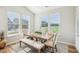 Bright dining area with a wooden table, bench seating, and views of the outdoors through large windows at 1973 Mobley Dr, Westfield, IN 46074