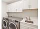 Functional laundry room with modern washer, dryer, sink, and white cabinets at 1973 Mobley Dr, Westfield, IN 46074
