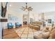 Open-concept living room with wood floors flowing into the kitchen area, ceiling fan, and comfortable seating at 1973 Mobley Dr, Westfield, IN 46074
