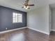 Bright bedroom showcasing a modern ceiling fan, window, and accent wall for a cozy feel at 212 Westridge Blvd, Greenwood, IN 46142