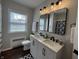 Modern bathroom featuring double sinks, stylish mirrors, black fixtures, and herringbone cabinet detailing at 2135 Union St, Columbus, IN 47201