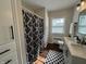 Bright bathroom featuring a shower with patterned curtain, double sink vanity, and patterned rug at 2135 Union St, Columbus, IN 47201
