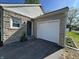 Home exterior featuring stone accents, attached garage, and a well-maintained yard at 2135 Union St, Columbus, IN 47201
