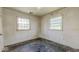 Bedroom featuring peeling paint, damaged flooring and two windows at 2219 N Webster Ave, Indianapolis, IN 46219