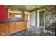 Kitchen cabinets with dark countertops and an open doorway leading to other rooms at 2219 N Webster Ave, Indianapolis, IN 46219