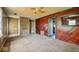Spacious living room featuring wood paneling, carpet flooring, and a ceiling fan at 2219 N Webster Ave, Indianapolis, IN 46219