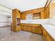 Spacious kitchen featuring wooden cabinets, neutral countertops, and a bright window at 225 E 36Th St, Anderson, IN 46013