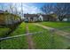 Large backyard with a stone path, fenced perimeter, and a detached shed in the distance at 241 S Rural St, Indianapolis, IN 46201