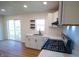Bright kitchen with stainless steel oven, black hardware, floating shelves and white cabinets and countertops at 241 S Rural St, Indianapolis, IN 46201