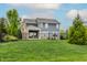 Expansive backyard with black fence, lawn, mature trees, covered patio, and basketball hoop for outdoor enjoyment at 2785 W High Grove Cir, Zionsville, IN 46077