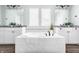 Bathroom highlighting the soaking tub, double vanity, tile backsplash, and wood-look flooring at 2785 W High Grove Cir, Zionsville, IN 46077