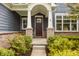 Charming front entrance with brick accents, a covered porch, and a well-maintained garden landscape at 2785 W High Grove Cir, Zionsville, IN 46077