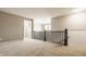 Open hallway with dark railings and neutral carpet, offering seamless flow and access to different living spaces at 2785 W High Grove Cir, Zionsville, IN 46077