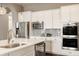Modern kitchen with stainless steel appliances, a large island, and stylish white cabinets at 2785 W High Grove Cir, Zionsville, IN 46077