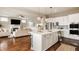 Open-concept kitchen features stainless appliances, a large island with seating, and views of the living area at 2785 W High Grove Cir, Zionsville, IN 46077