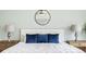 Close up of bed with blue decorative pillows, bedside lamps, and wooden nightstands for a relaxed space at 2785 W High Grove Cir, Zionsville, IN 46077
