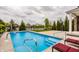 Stunning pool with basketball hoop surrounded by lush landscaping and a patio with lounge seating at 2785 W High Grove Cir, Zionsville, IN 46077