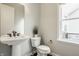 Charming powder room with pedestal sink, framed mirror, and classic fixtures near a window for natural light at 2785 W High Grove Cir, Zionsville, IN 46077
