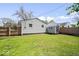 View of the fenced backyard showing the home's exterior, storage shed, and green grass at 3134 Orchard Ave, Indianapolis, IN 46218