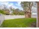 Spacious backyard featuring a wooden playhouse and white vinyl fencing for privacy and security at 3221 Washington St, Columbus, IN 47203