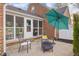 Charming stone patio with fire pit, chairs, umbrella, and screened in porch at 3221 Washington St, Columbus, IN 47203