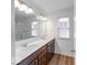 Bathroom with double sink vanity, large mirror, updated lighting, and wood-look flooring at 326 N Warman Ave, Indianapolis, IN 46222