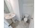 Cozy bathroom with a pedestal sink, toilet, and neutral-colored tile flooring at 326 N Warman Ave, Indianapolis, IN 46222