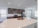 Bright kitchen with stainless steel appliances, dark cabinets, and an island with a sink at 326 N Warman Ave, Indianapolis, IN 46222