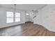 Open-concept living room with hardwood floors, contemporary lighting, and staircase at 326 N Warman Ave, Indianapolis, IN 46222