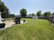Expansive backyard with a grill and patio set, bordered by a wooden fence and trees at 326 Virginia St, Fortville, IN 46040