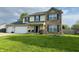 Charming two-story home with a well-manicured lawn, two-car garage, and decorative blue shutters at 326 Virginia St, Fortville, IN 46040