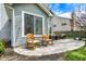 A stone back patio features rocking chairs and an outdoor seating area for relaxing and enjoying the fresh air at 3466 Firethorn Dr, Whitestown, IN 46075