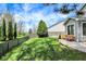 Beautiful backyard with a grassy lawn, wooden fence, and lush trees at 3466 Firethorn Dr, Whitestown, IN 46075