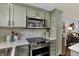 Updated kitchen featuring a stainless steel microwave, cooktop, and light green cabinetry at 3466 Firethorn Dr, Whitestown, IN 46075