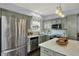 Modern kitchen featuring stainless steel appliances, a center island with quartz countertop, and light green cabinets at 3466 Firethorn Dr, Whitestown, IN 46075