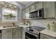 Charming kitchen with stainless steel appliances and beautiful light green cabinetry at 3466 Firethorn Dr, Whitestown, IN 46075